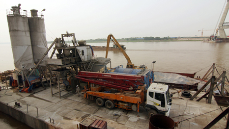 Trạm trộn bê tông đặt trên chiếc phà khổng lồ phục vụ cho việc thi công tháp giữa sông